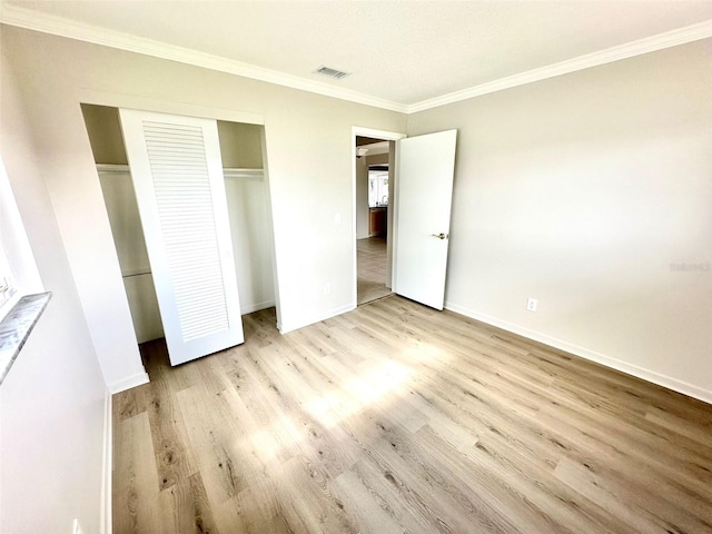 unfurnished bedroom with ornamental molding, a closet, and light hardwood / wood-style flooring