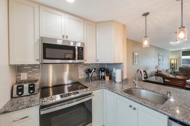 kitchen featuring decorative backsplash, pendant lighting, stainless steel appliances, and stone countertops