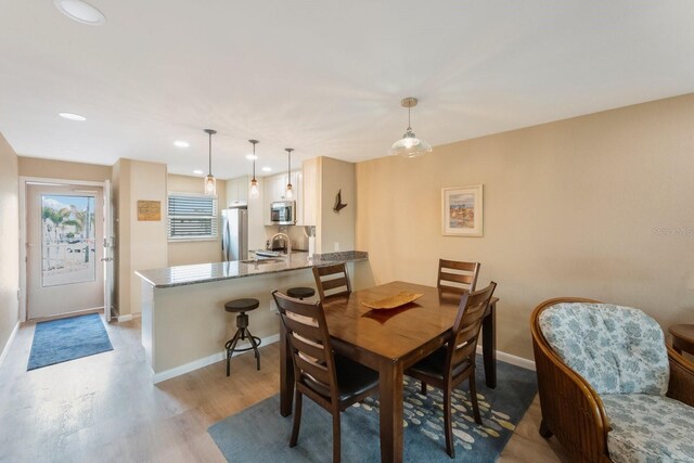 dining room with light hardwood / wood-style floors and sink