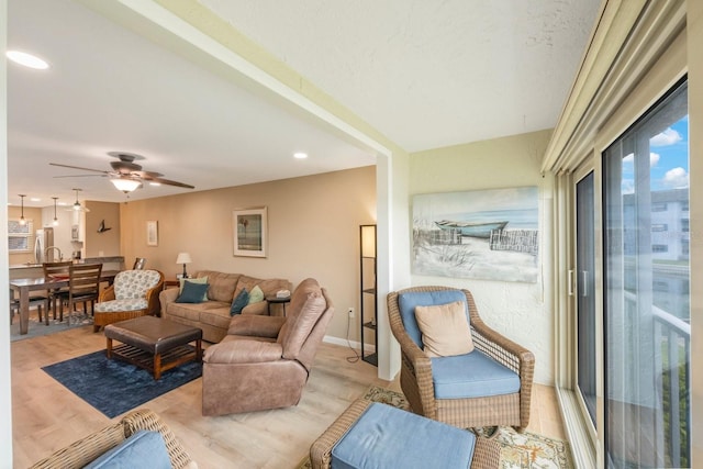 living room featuring light hardwood / wood-style floors and ceiling fan