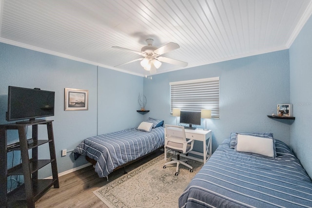 bedroom featuring ceiling fan, wood-type flooring, and ornamental molding