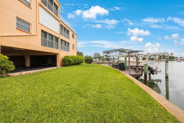 dock area with a yard and a water view