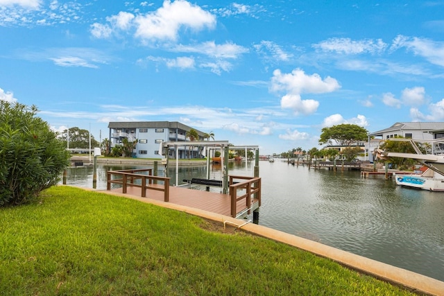 view of dock with a yard and a water view