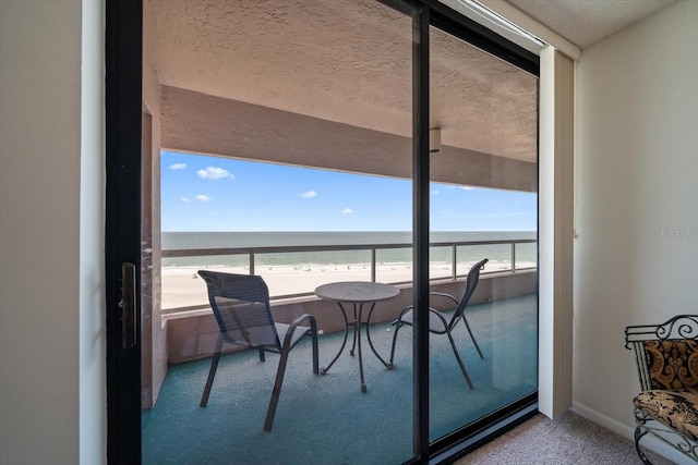 balcony with a water view and a beach view