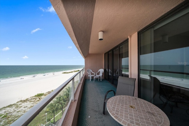 balcony featuring a water view and a beach view