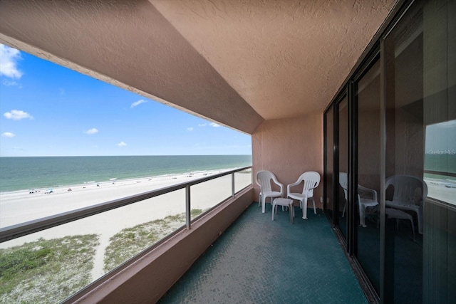 balcony with a water view and a beach view