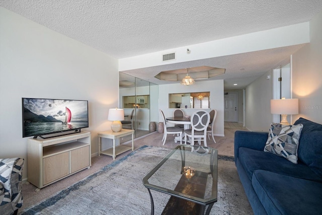 living room with carpet floors, a textured ceiling, and a tray ceiling