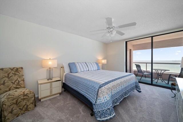 carpeted bedroom with a water view, a textured ceiling, ceiling fan, and access to exterior