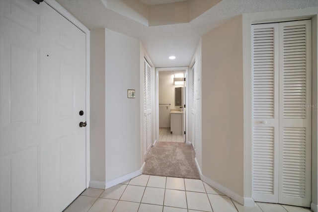 hallway with light tile patterned floors and a textured ceiling