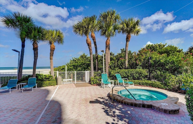 view of swimming pool featuring a patio, a water view, and a community hot tub