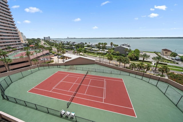 view of tennis court featuring a water view