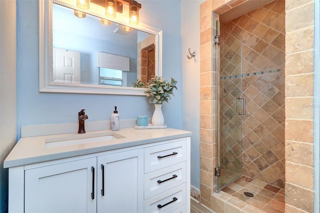 bathroom with a shower with door and vanity