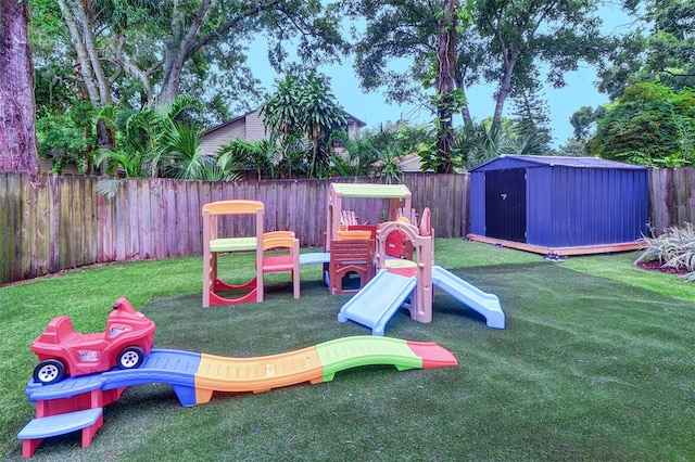 view of playground with a yard and a storage shed