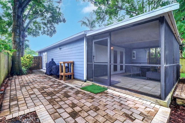 rear view of house featuring a patio area and a sunroom