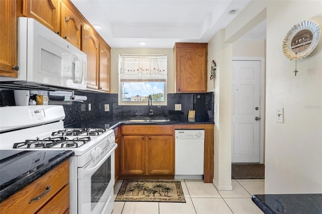 3128 59th St S Unit 214, Gulfport, FL 33707 - kitchen with white appliances, a sink, tasteful backsplash, and brown cabinets