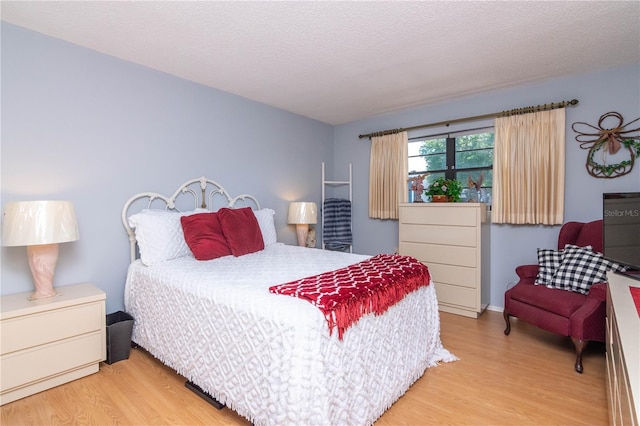 bedroom featuring a textured ceiling and light wood-type flooring