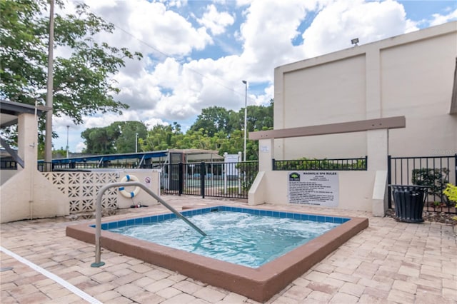 view of swimming pool featuring a patio and a hot tub