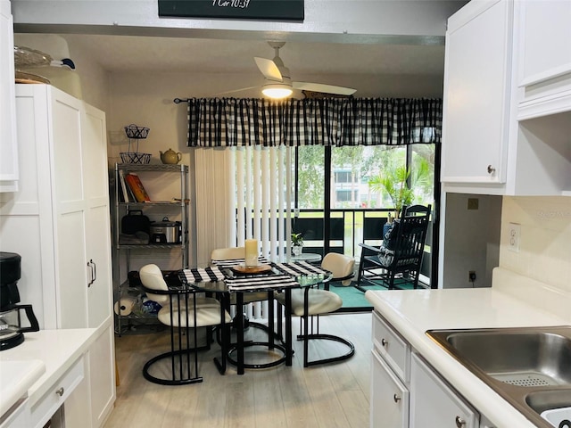 kitchen featuring ceiling fan, light hardwood / wood-style flooring, white cabinets, and sink