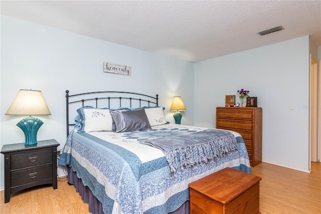 bedroom featuring light wood-type flooring and a textured ceiling