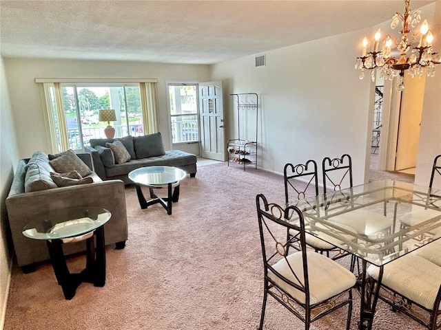 carpeted living room featuring a notable chandelier and a textured ceiling