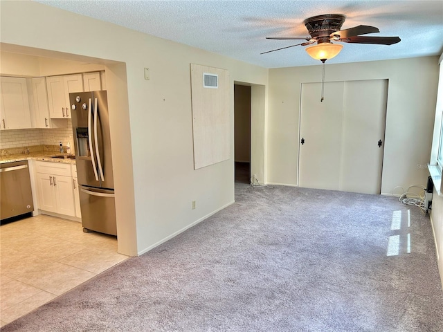 kitchen featuring white cabinetry, sink, ceiling fan, stainless steel appliances, and tasteful backsplash