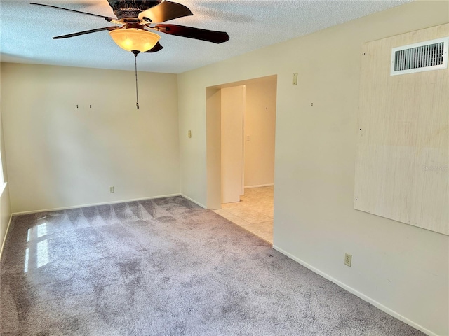 unfurnished room featuring light carpet, a textured ceiling, and ceiling fan