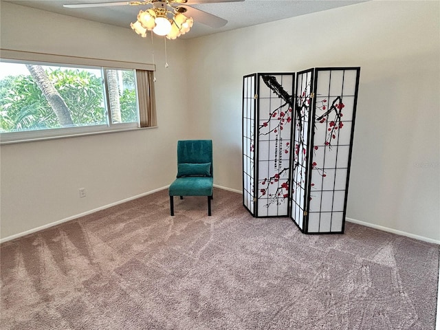 living area featuring carpet and ceiling fan