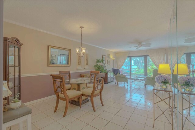 dining space with light tile patterned floors, ceiling fan with notable chandelier, and ornamental molding