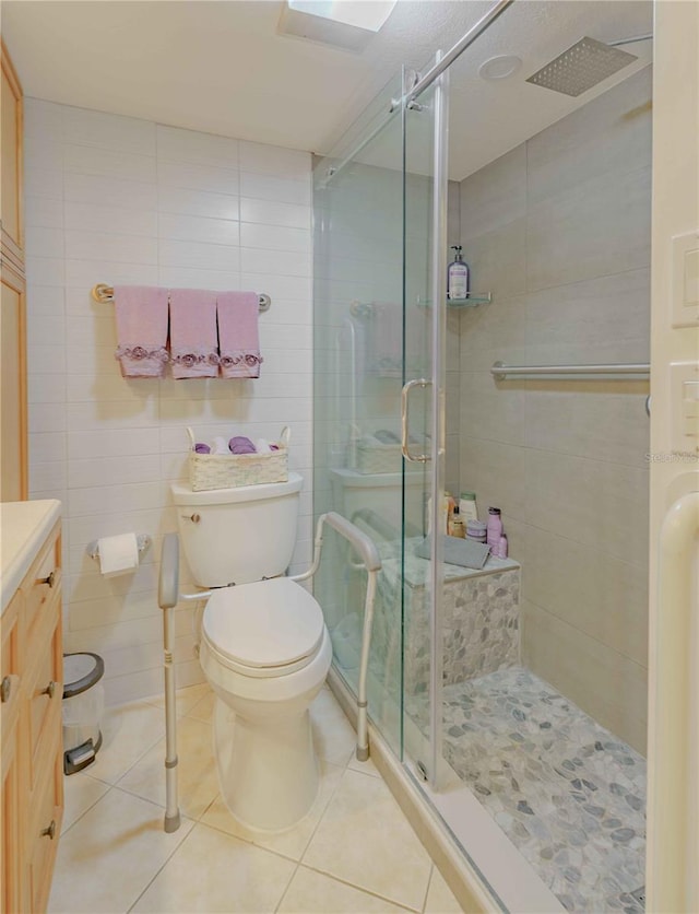 bathroom with toilet, vanity, tile patterned floors, and walk in shower