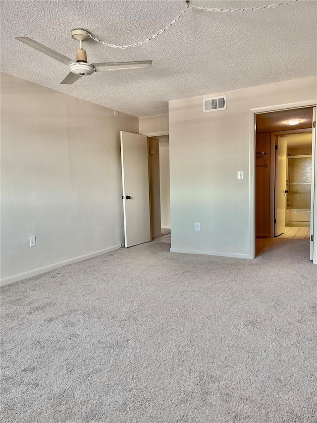 carpeted spare room with a textured ceiling and ceiling fan