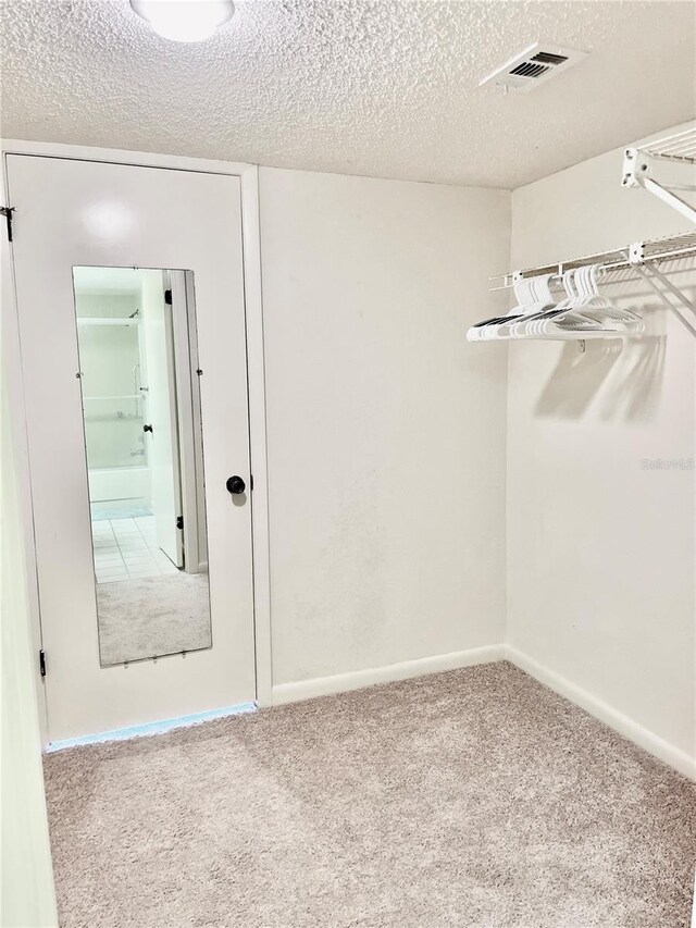 carpeted spare room featuring a textured ceiling