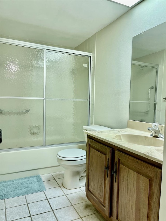 full bathroom featuring tile patterned floors, toilet, combined bath / shower with glass door, and vanity