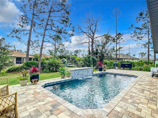 view of pool with a patio and pool water feature