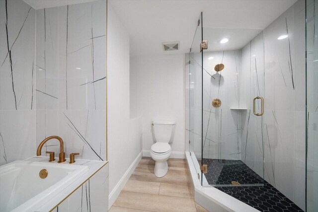 bathroom with hardwood / wood-style floors, toilet, and independent shower and bath