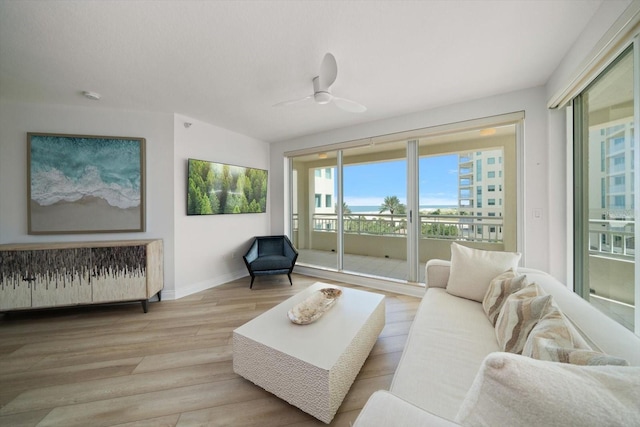 living area featuring ceiling fan, wood finished floors, and baseboards