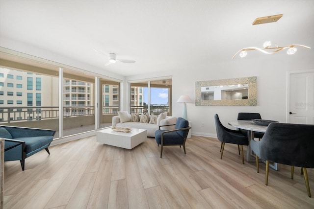 living area with a chandelier, wood finished floors, and baseboards