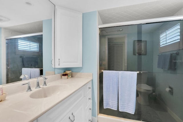 bathroom featuring vanity, toilet, and an enclosed shower