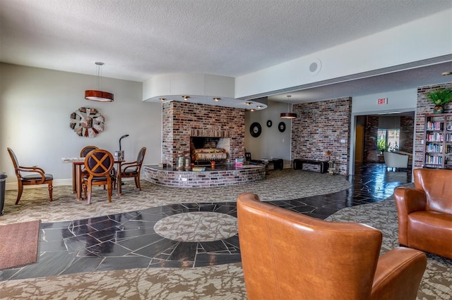 living room featuring a brick fireplace and a textured ceiling