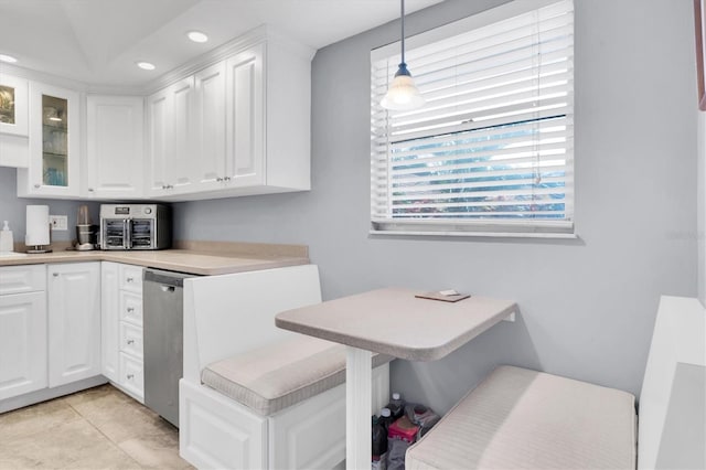 kitchen featuring white cabinetry, light tile patterned floors, breakfast area, dishwasher, and pendant lighting
