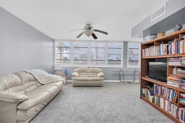 carpeted living room with ceiling fan