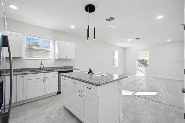 kitchen with a center island, dishwasher, white cabinets, and sink