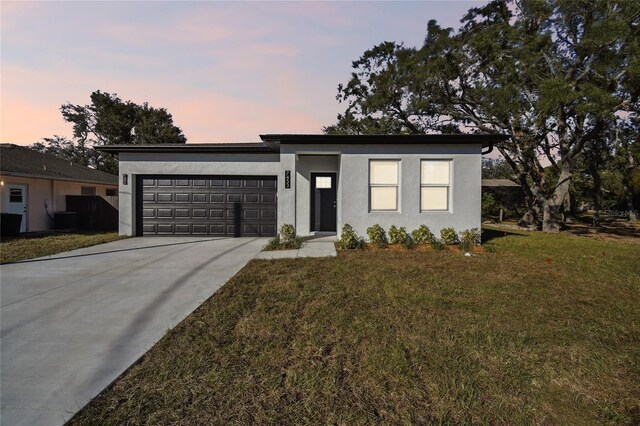 view of front of house with a garage and a lawn