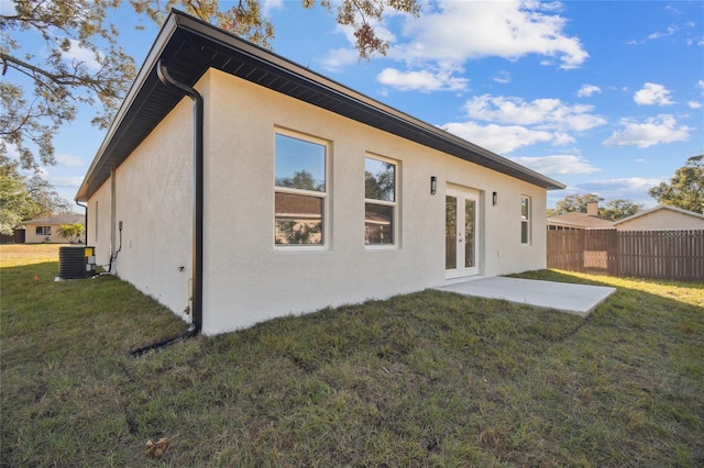 back of property with central AC, french doors, a yard, and a patio