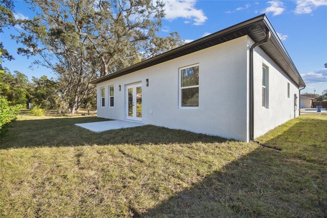 rear view of property featuring a yard and a patio