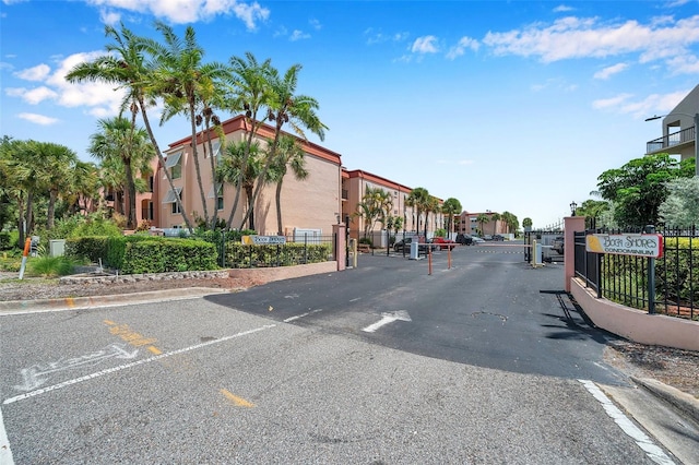 view of road with a residential view, a gate, curbs, and a gated entry