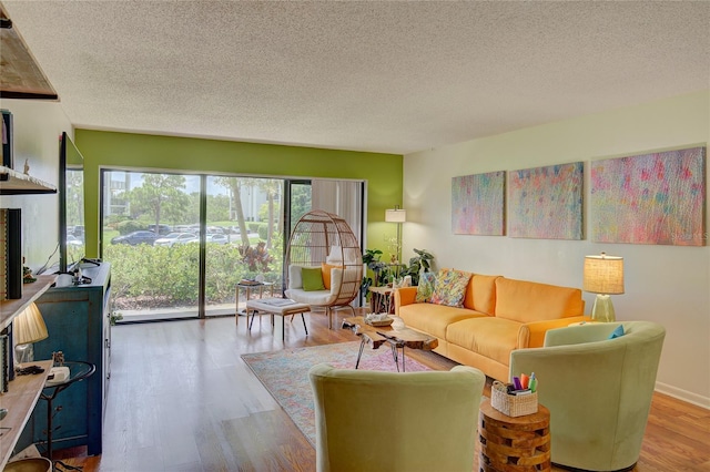 living room featuring wood-type flooring and a textured ceiling