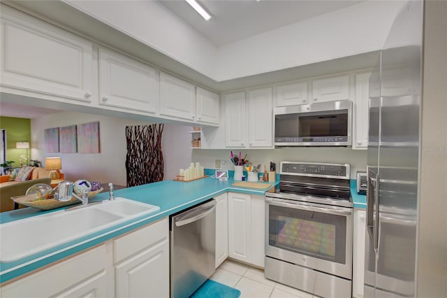 kitchen with white cabinets, sink, stainless steel appliances, and light tile patterned flooring