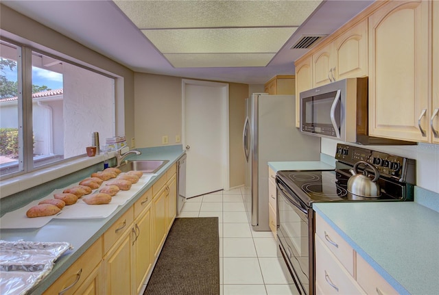 kitchen featuring light brown cabinets, sink, stainless steel appliances, and light tile patterned flooring