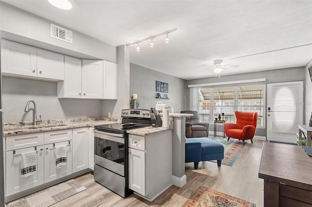 kitchen with sink, white cabinets, stainless steel range with electric stovetop, and light wood-type flooring