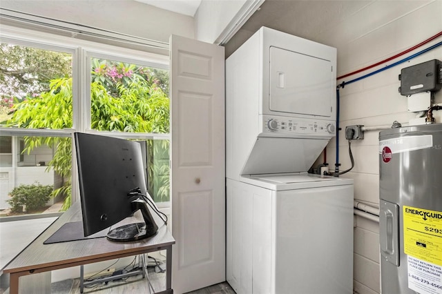 washroom featuring stacked washing maching and dryer and water heater